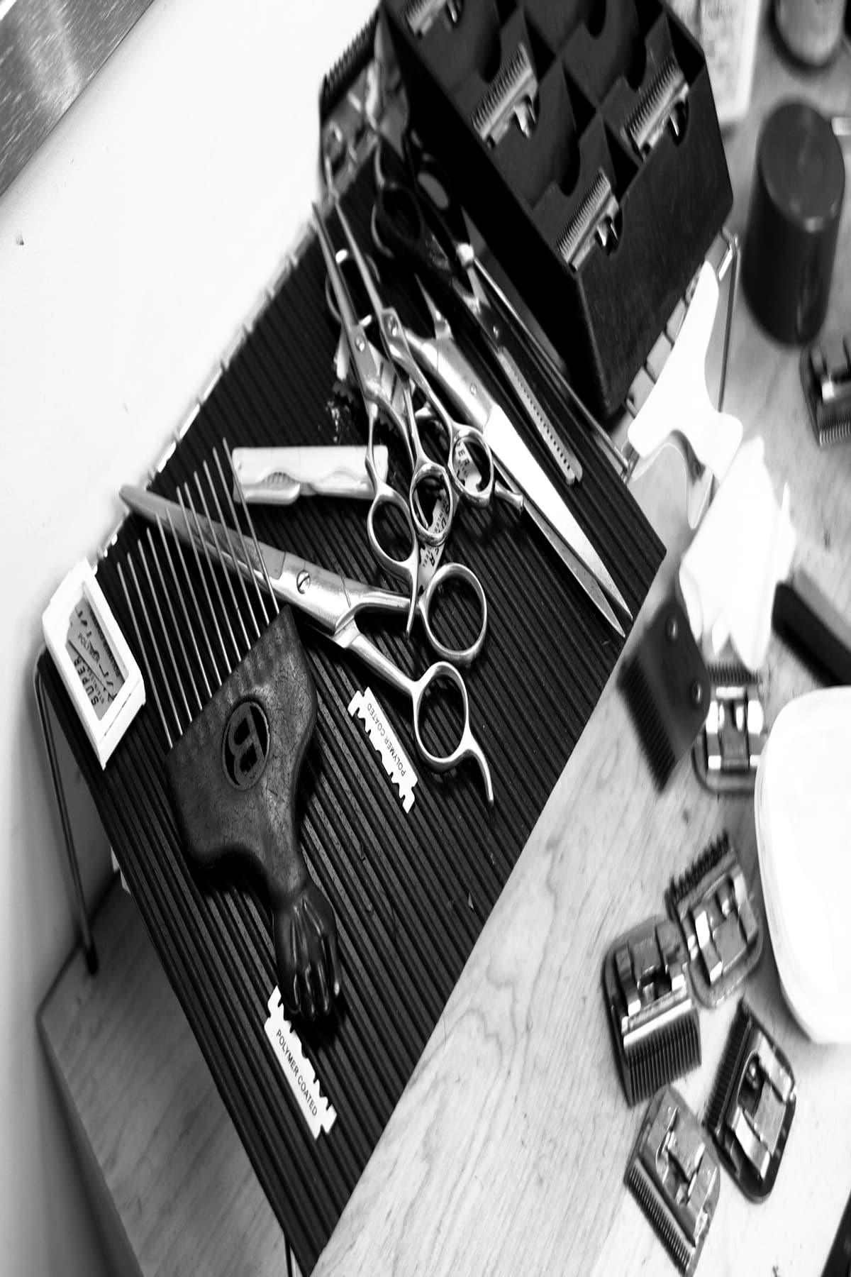 Shears, clipper guards and combs laid out on a barber's station